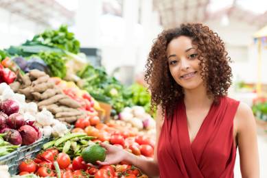 a woman posing for picture near grocery shop